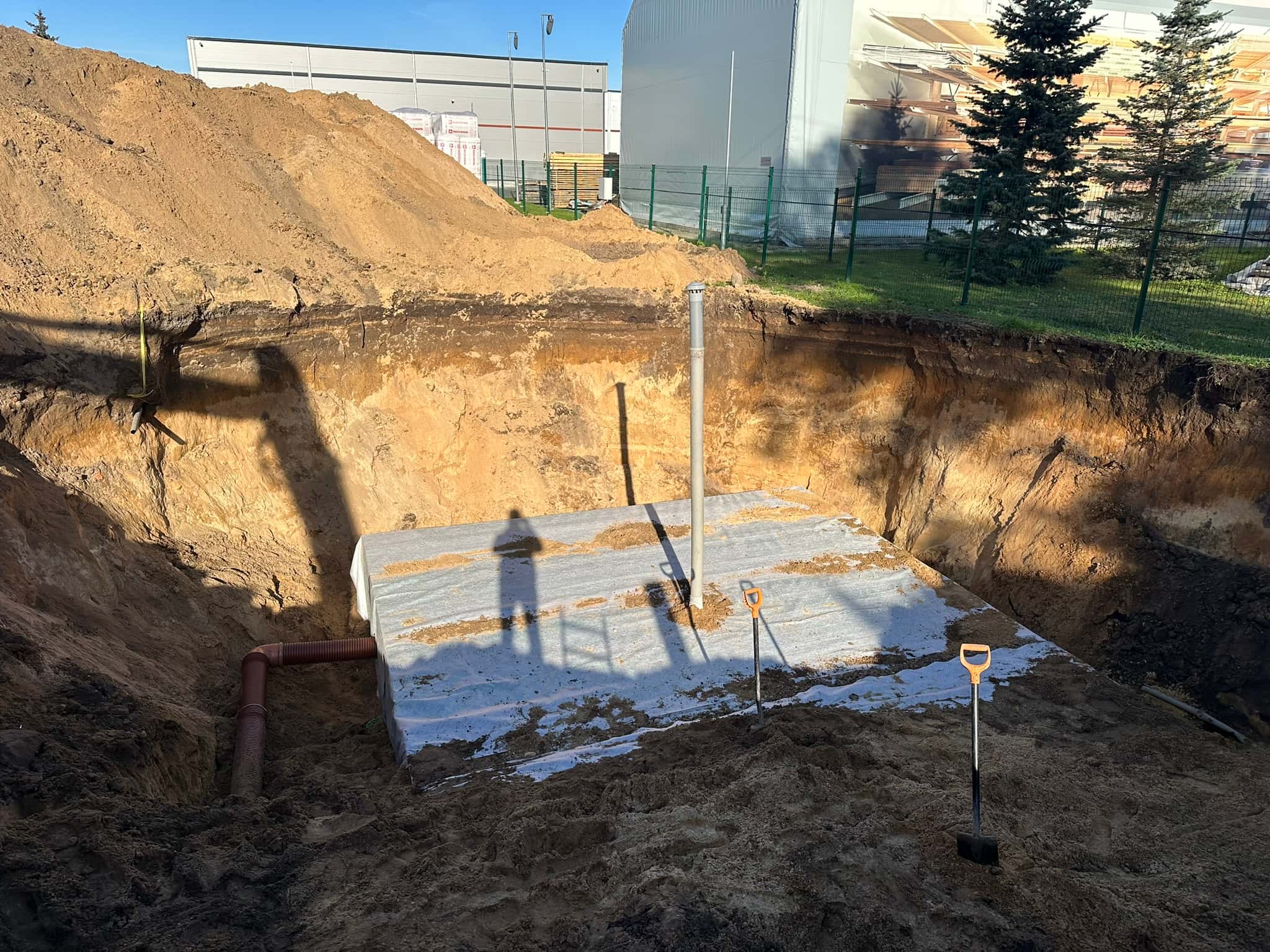 Daļēji aizbērta lietusūdens infiltrācijas sistēma būvbedrē
