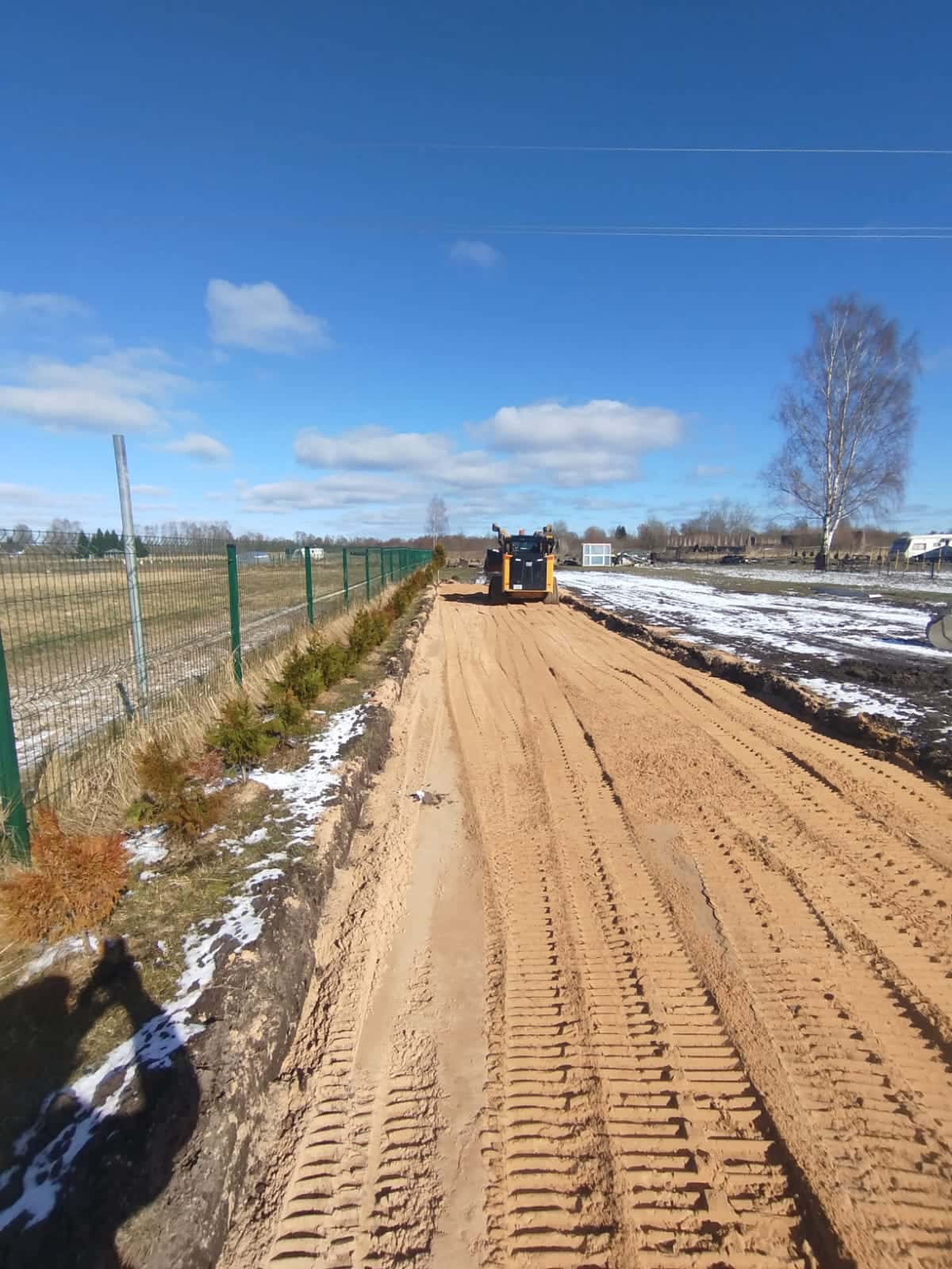 Smilts pamatnes planēšana pievadceļam gar īpašuma žogu